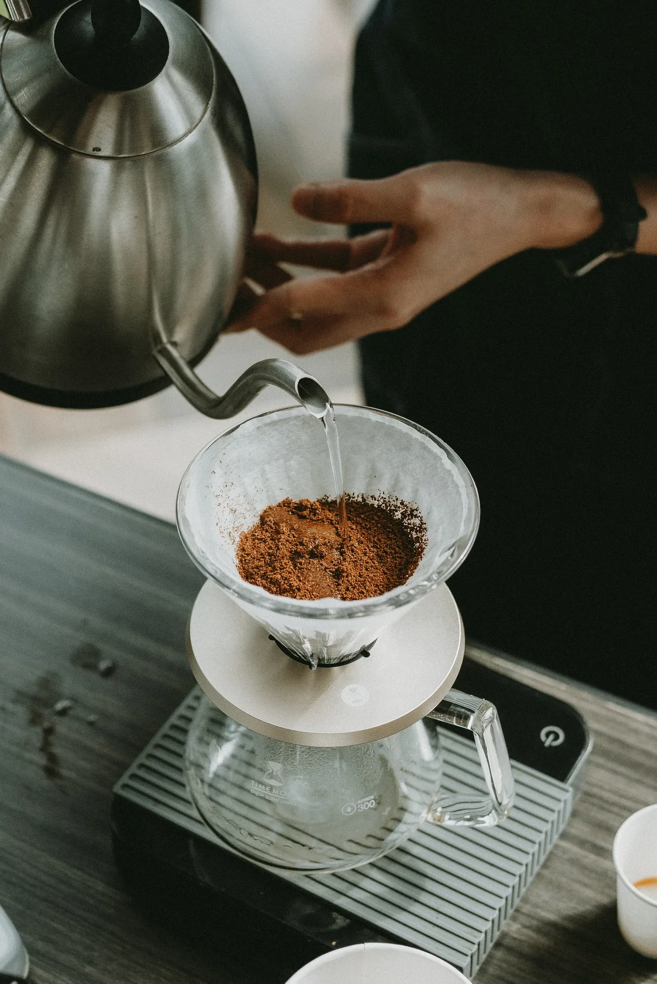 Water poured from a gooseneck kettle into a pour-over coffee filter
